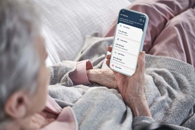 Old woman looking at her health data in the Dawn House app on her device.
